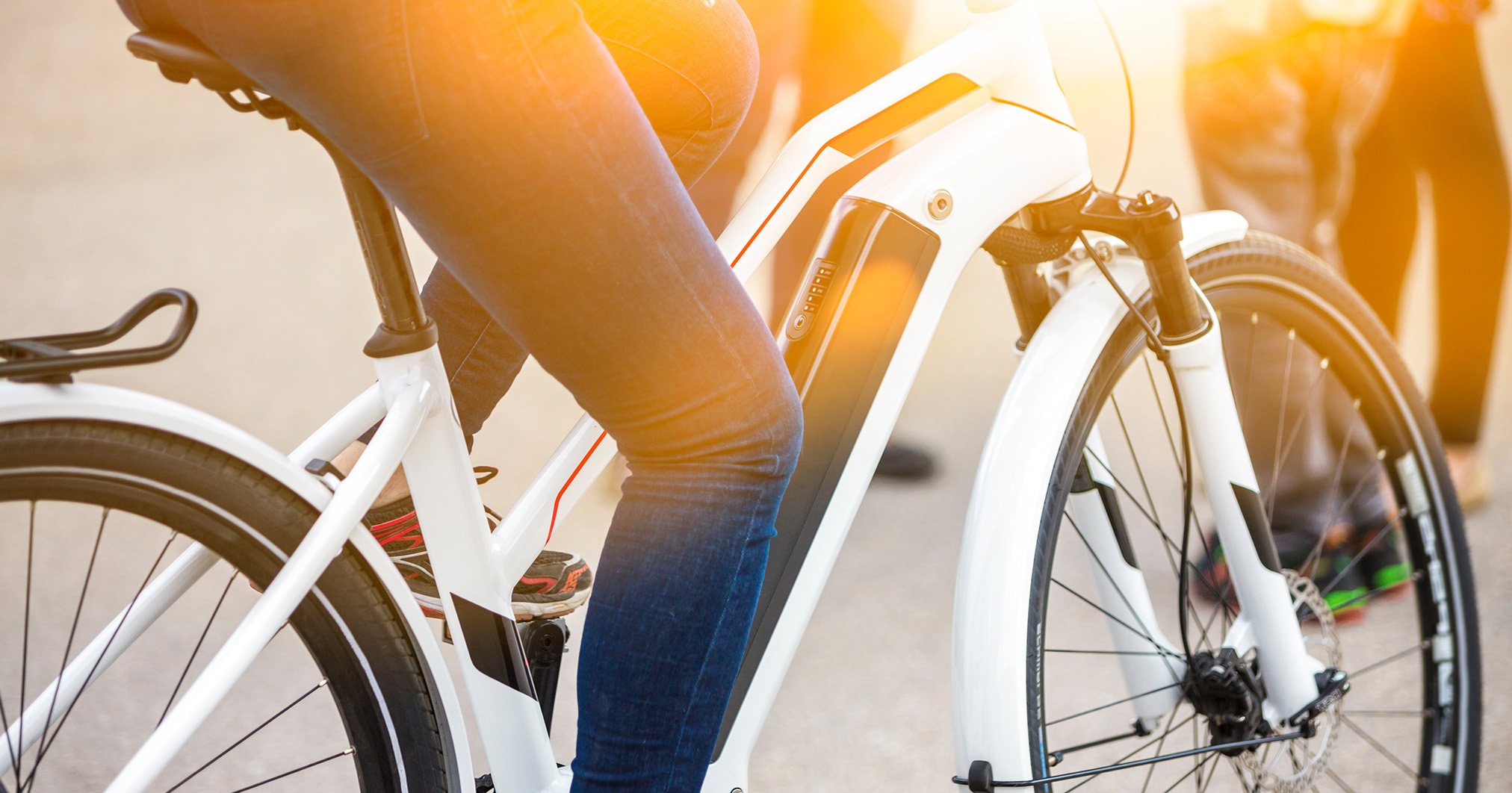 Elektrische fietser op een zonnige dag op een elektrische, witte fiets met middenmotor.